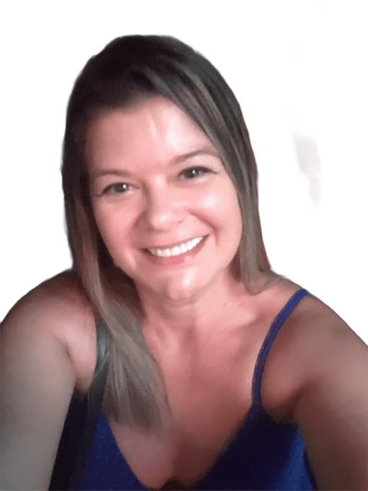 Um close-up de uma mulher sorrindo para a câmera. Ela tem cabelos loiros e castanhos claros e veste uma blusa azul de alças finas. Seus dentes brancos estão visíveis em seu sorriso aberto.